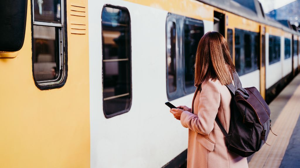Kobieta stojąca przed pociagiem