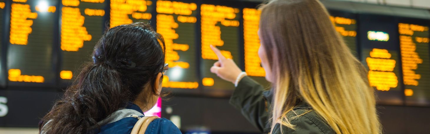 Kobiety patrzące na rozkład pociągów