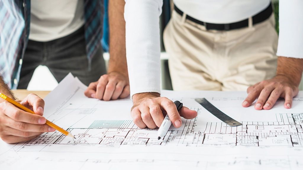 Ludzie czytający plany techniczne