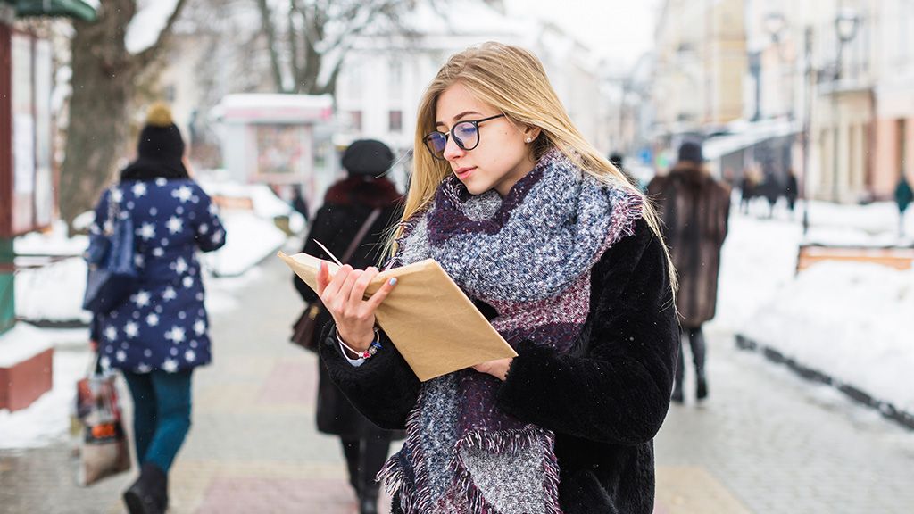 Kobieta czytająca książkę na ulicy