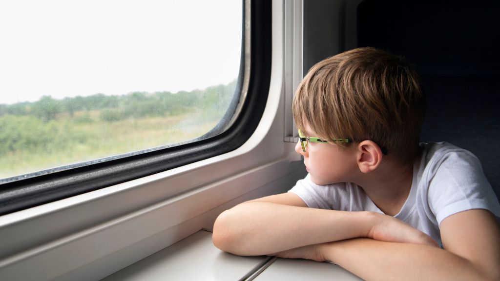 Dziecko siedzące przy oknie w pociągu