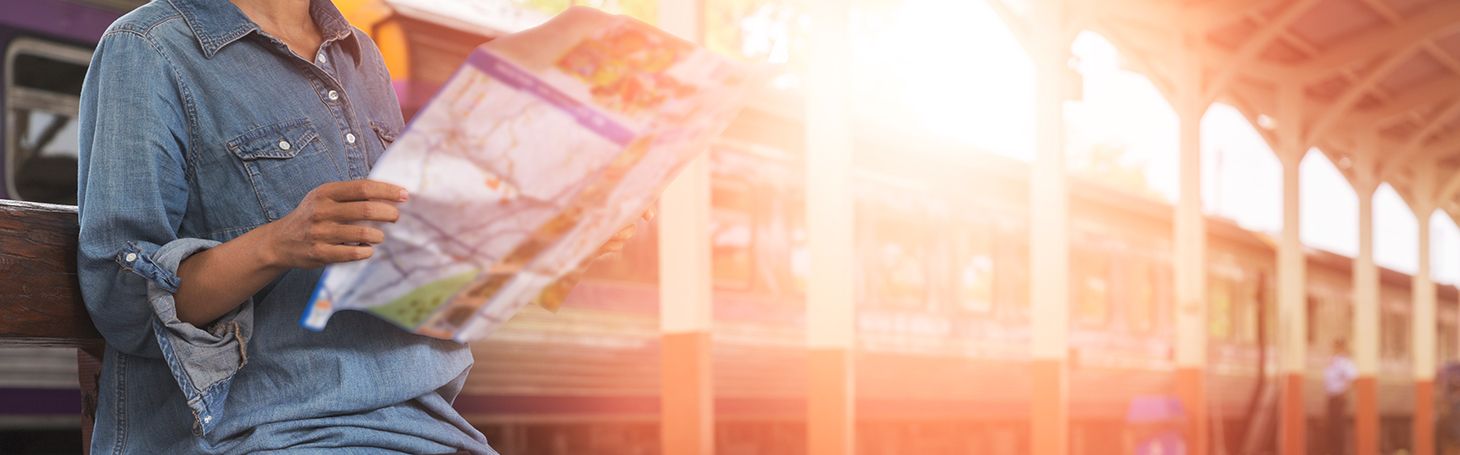 Kobieta siedząca na peronie i oglądająca mapę