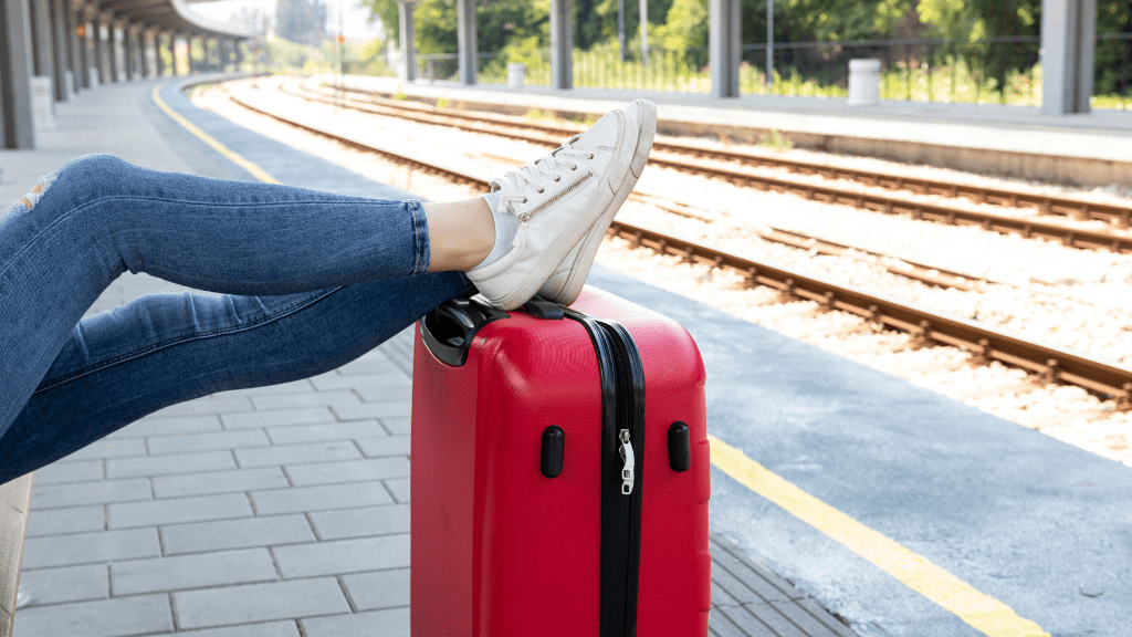 Kobieta z walizką czekająca na pociąg