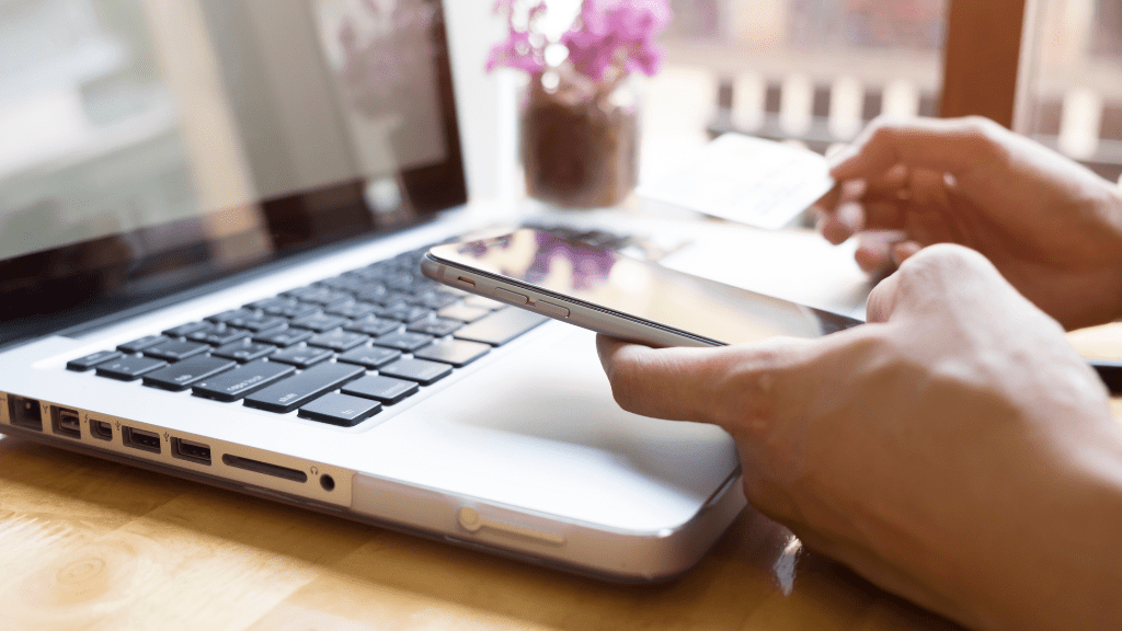 Osoba korzystająca z laptopa i telefonu