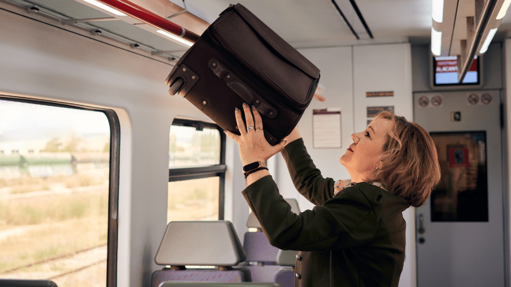 kobieta wkładajaca walizkę w pociagu