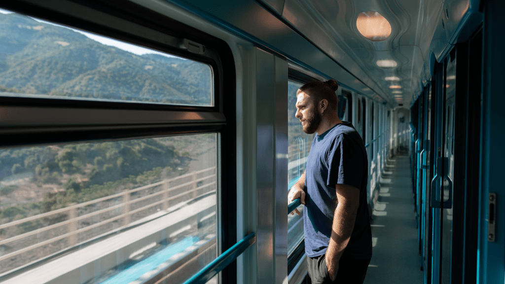 Mężczyzna spoglądający przez okno pociągu