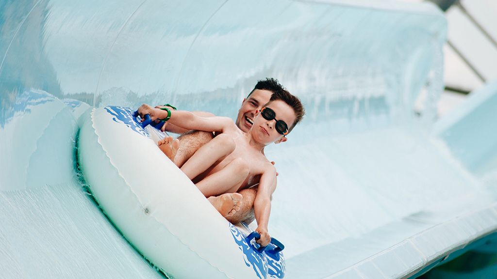 Mężczyzna z dzieckiem na zjeżdżalni wodnej