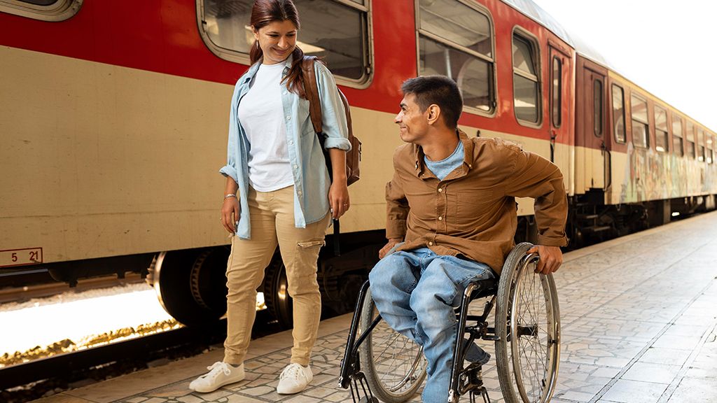 Mężczyzna na wózku inwalidzkim a obok niego kobieta