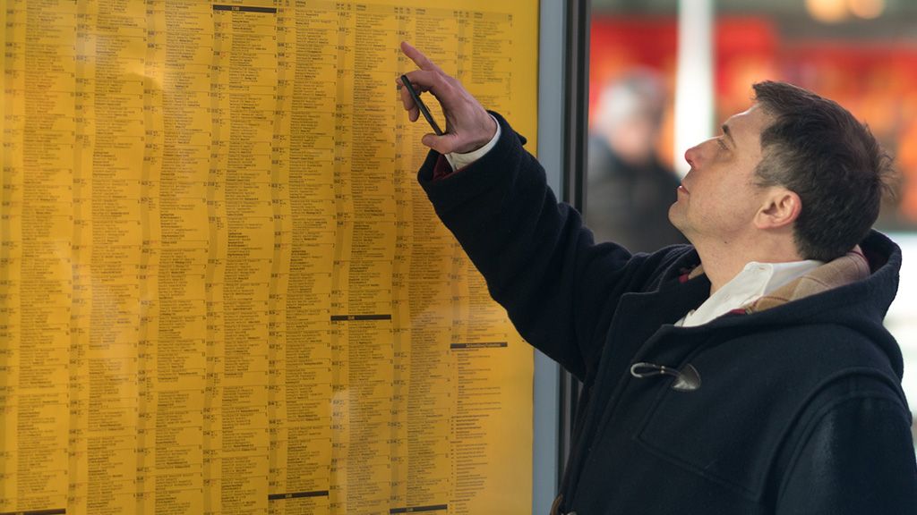 mężczyzna patrzący na rozkład jazdy