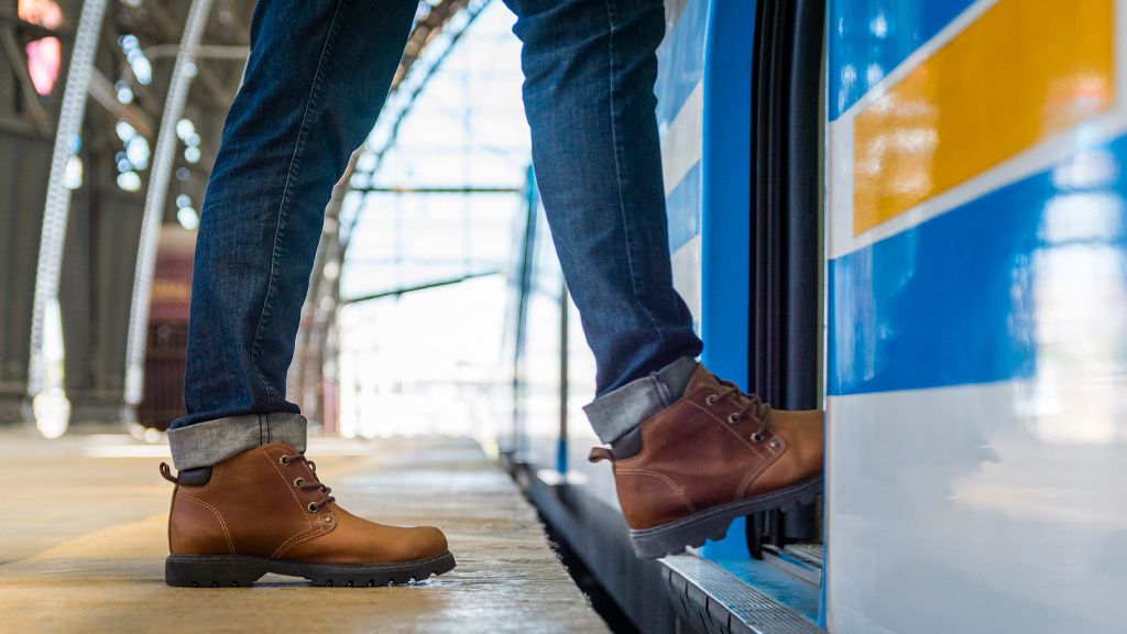 Mężczyzna wchodzący do pociągu - numeracja peronów i torów